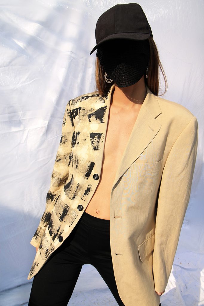 una modella con blazer beige e volto oscurato