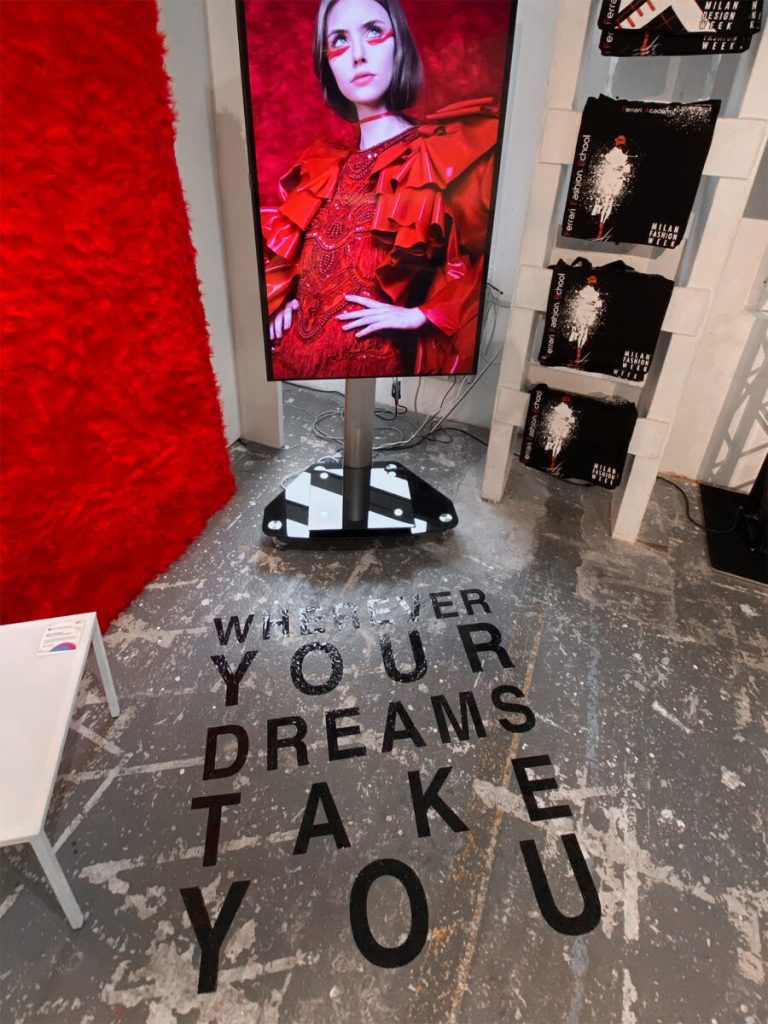 allestimento fashion graduate, pavimento con delle scritte e panneli con foto editoriali