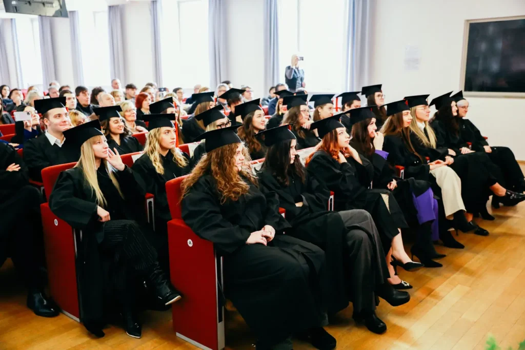 foto di gruppo degli studenti che si sono appena diplomati con toga e cappello