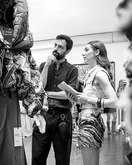 Studentessa presenta il capo ad un professionista durante lo showcase di Ferrari Fashion School.