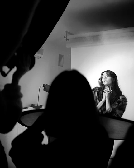 Studenti in studio fotografano la modella che posa.