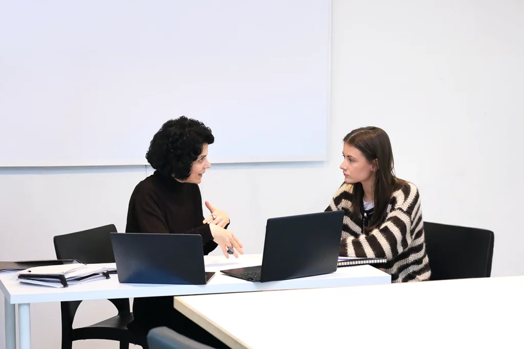 Studentessa e docente si confrontano su un progetto.