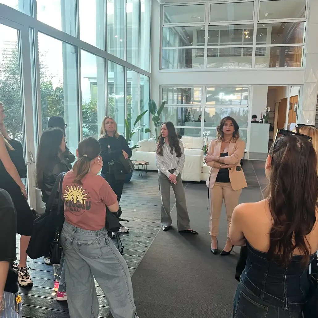 un gruppo di studentesse del Master all'interno di un locale con profumi che ascoltano una lezione