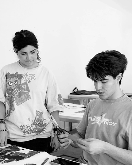 Studenti lavorano in classe ritagliando immagini.