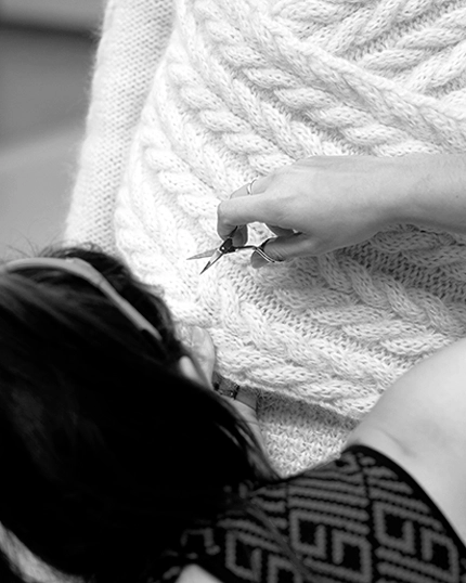 Studentessa lavora sui dettagli del capo fatto a maglia.