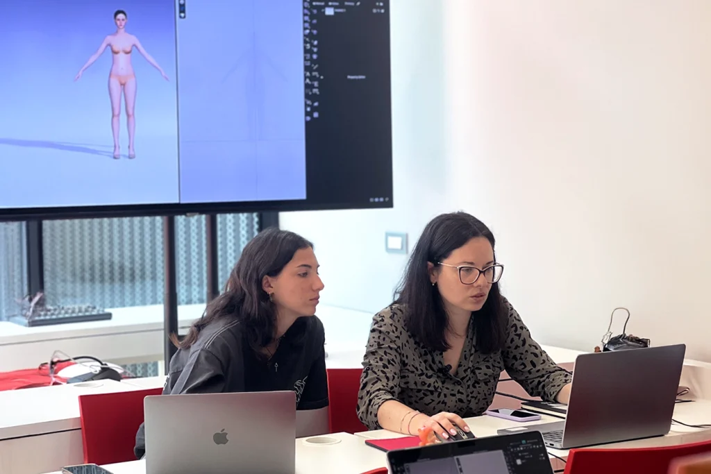 Studentessa fa revisione con la professoressa del suo lavoro al computer.