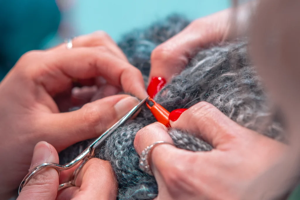 Studenti lavorano insieme ad un dettaglio della maglia.