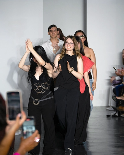 Studenti di Ferrari Fashion School sfilano al termine della sfilata Living Matters.