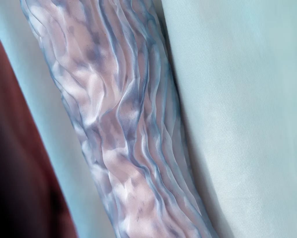 Dettaglio di una manica con un tessuto semitrasparente.