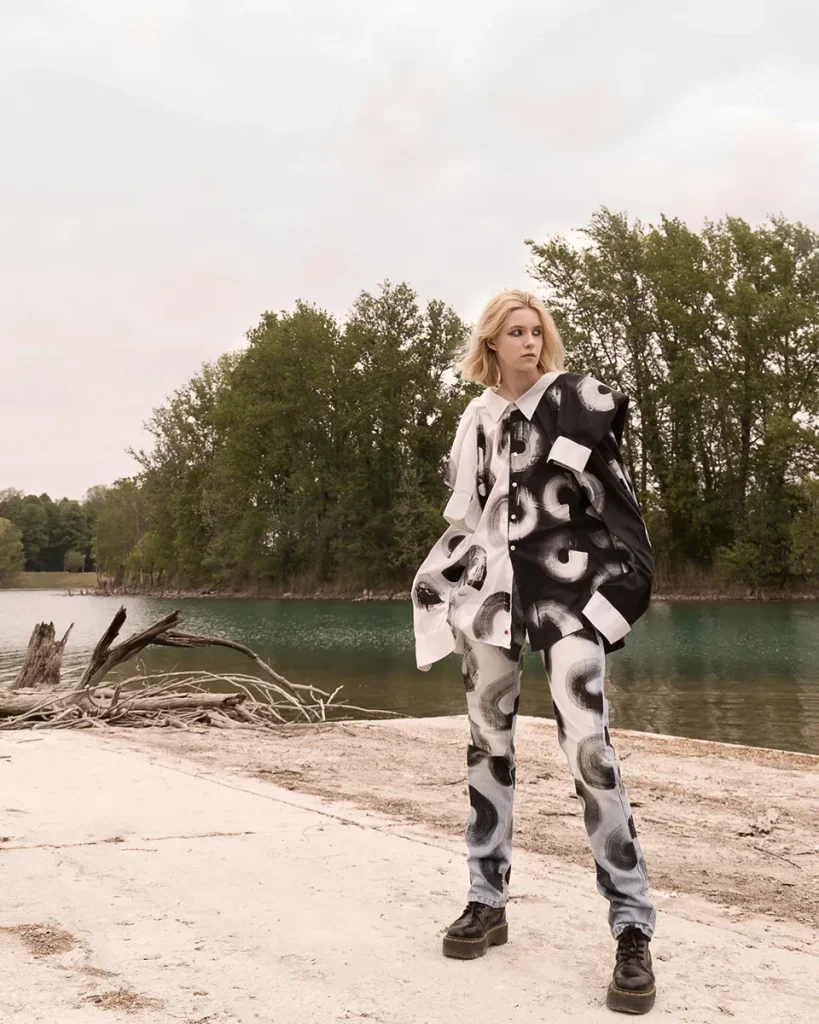 Modella indossa un completo bianco e nero dipinto con la vernice.